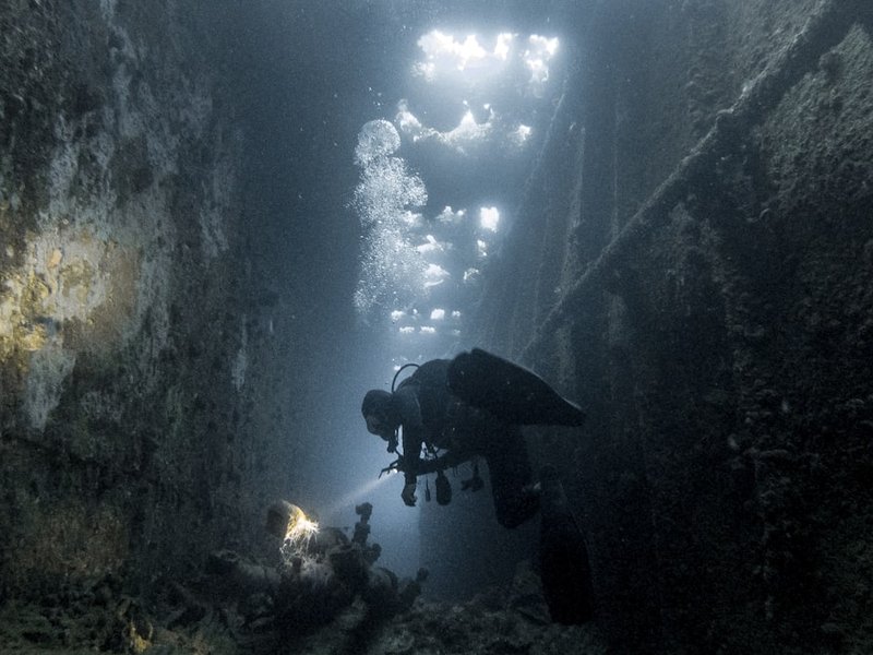 Diver exploring a WWII shipwreck underwater